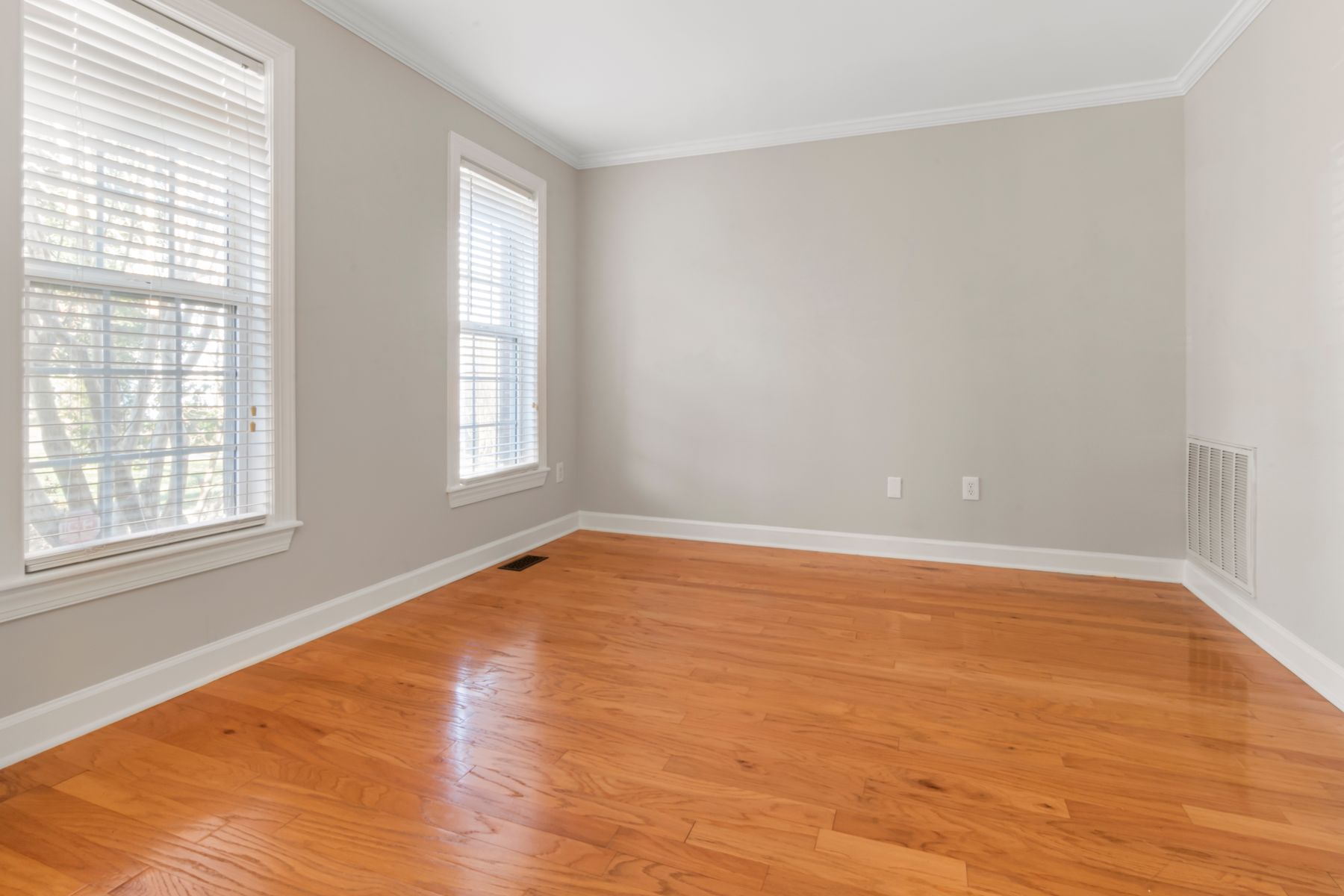 Newly installed hardwood flooring running through a bright room